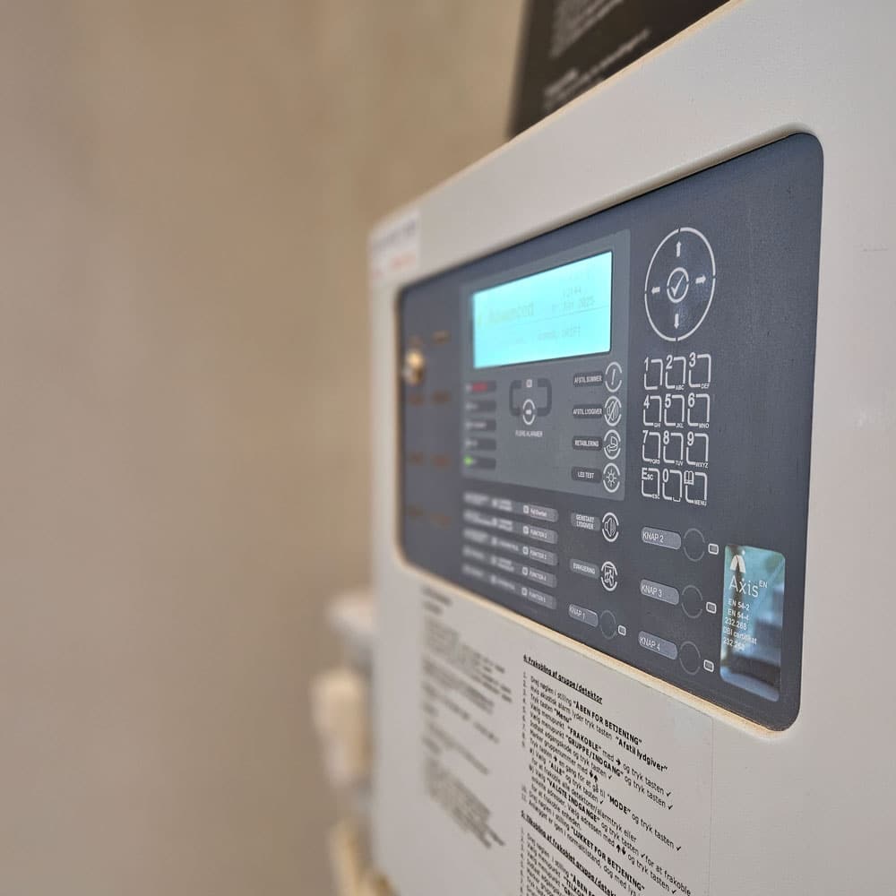 Nærbillede af brandalarmens ABA-betjeningspanel fra Advanced Axis EN med display og knapper