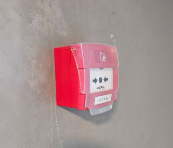 Rød trykknapmelder til brandalarm (ABA) monteret på indendørs væg, model XP95
